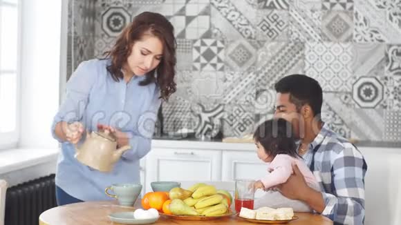 快乐的一家人早上一起在厨房的家里吃早餐视频的预览图