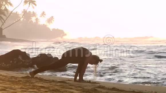 清晨阳光下练瑜伽的年轻女性剪影视频的预览图