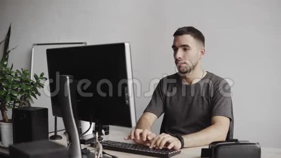 年轻人开始使用虚拟现实护目镜耳机坐在办公室里对着电脑试图触摸视频的预览图