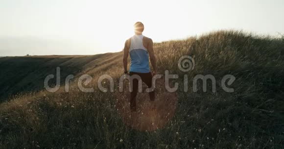 男子慢跑训练马拉松跑在山上轮廓与五颜六色的黄色天空健身健身模型视频的预览图