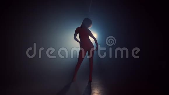在烟雾弥漫的黑暗背景上美丽的舞者的剪影聚光灯照回性感女孩她动人心弦视频的预览图