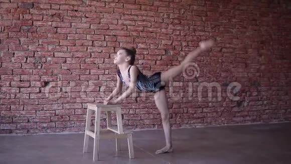 漂亮的女孩子艺术体操运动员穿着表演服在工作室做热身做肌肉伸展运动视频的预览图