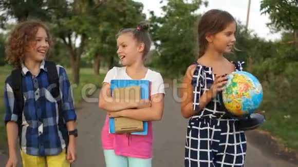 可爱的卷发男孩和他的两个女朋友去上学孩子说话热情女生们在听A视频的预览图