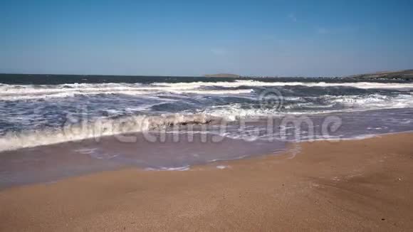 在阳光明媚的夏日里在一片荒凉的沙滩上在小山的背景下大风暴汹涌而来视频的预览图