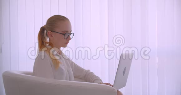 特写侧景照片年轻漂亮的白种人金发女商人戴着眼镜用笔记本电脑笑得开心视频的预览图
