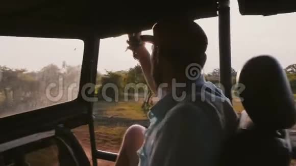 年轻快乐放松的旅行者在史诗般的日落热带森林远足乘坐狩猎车阳光照耀通过视频的预览图