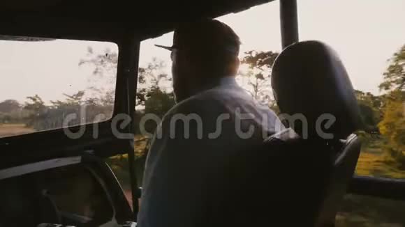 年轻快乐放松的男性游客乘坐旅游观光车欣赏美丽的日落森林阳光透过视频的预览图