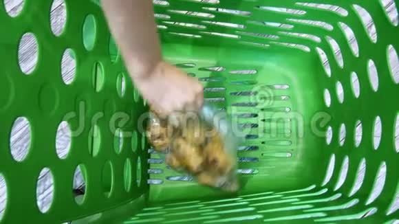 女性手把蔬菜和水果放到超市手推车上视频的预览图