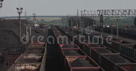 全景列车装载煤炭铁路车辆在车站与矿石运输矿物满载的货车视频的预览图