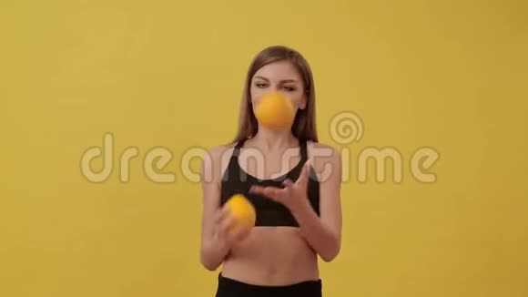 活泼的女孩在给成熟的橘子杂耍健康生活方式视频的预览图