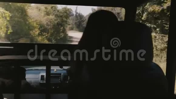 后景年轻的女游客坐在萨法里汽车卡车的乘客休息室里驶入斯里兰卡的野生森林视频的预览图