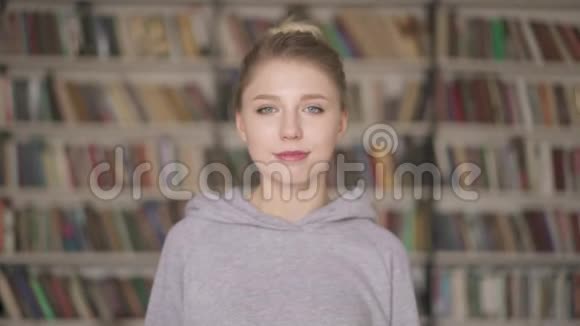 站在图书馆的年轻女学生微笑的肖像视频的预览图