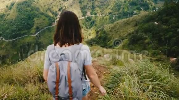 后景年轻的旅游妇女背着背包踏下陡峭的山路史诗般的斯里兰卡慢动作景色视频的预览图