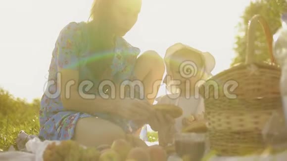 小女孩和她妈妈在阳光明媚的夏日一起野餐视频的预览图