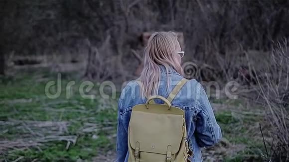 这女孩是一片废弃的城市荒地摄像机从后面拍摄在电影院散步视频的预览图