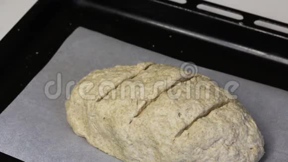 烤片上有一块用面粉做的面团就像一条带切的面包女人洒了我视频的预览图