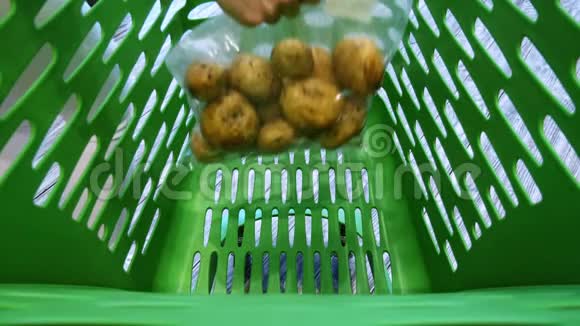 超市手推车的特写女人把蔬菜和水果放到篮子里视频的预览图