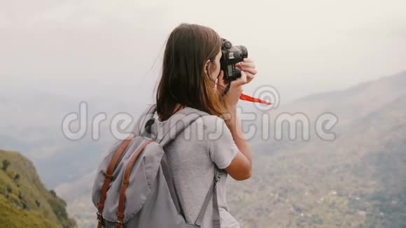 后景年轻的旅游妇女带着背包和相机拍摄斯里兰卡史诗般令人叹为观止的山景视频的预览图