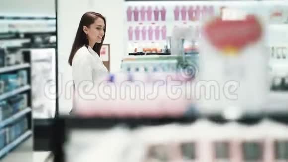 美丽的女孩在化妆品店的货架上慢动作稳定镜头视频的预览图