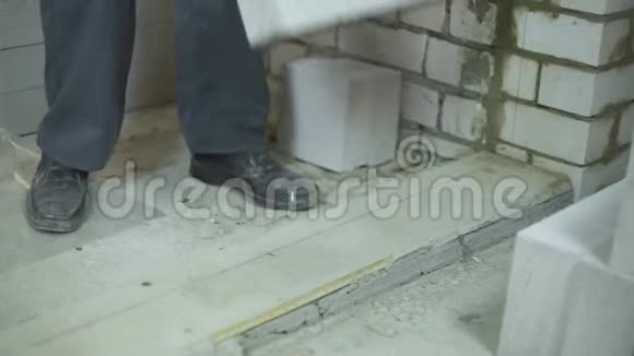 根据地面基础上的标记将建筑工人铺设第一块的倾斜度视频的预览图