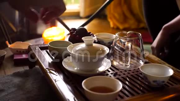 在中国传统的茶道中一个人用一个木制的贡夫茶桌和茶用一个陶制茶壶倒红茶视频的预览图