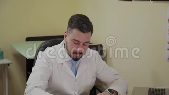 男医生在桌旁的笔记本上写字视频的预览图