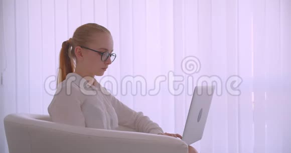 特写侧景照片年轻漂亮的白种人金发女商人戴着眼镜用笔记本电脑笑得开心视频的预览图