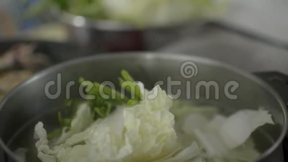 生猪肉和鱿鱼在锅里烤着在火锅里准备混合蔬菜汤视频的预览图
