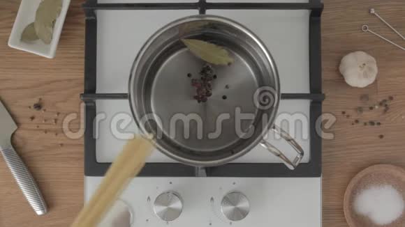 在厨房的煤气炉上用调味水将意大利面条放入金属锅中视频的预览图