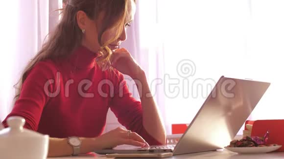 靠近智能手机的笔记本电脑旁的近景金发女性视频的预览图