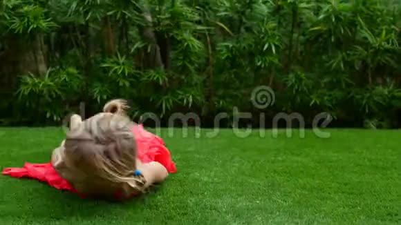 女孩骑在绿草上在新鲜空气中行走一个女孩在草地上翻滚视频的预览图