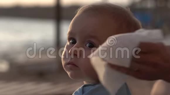 妈妈用餐巾纸慢擦着宝宝的鼻子视频的预览图