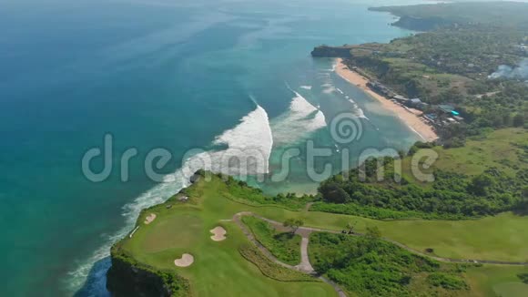 美丽的巴厘岛风景与高尔夫球场和绿松石海洋与波浪空中视频的预览图