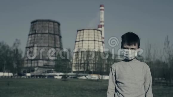 年轻的戴污染面具抓住他的头和遗憾住在烟囱厂的人视频的预览图