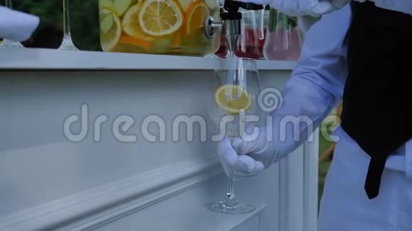 在婚礼或生日聚会上服务员把柑橘柠檬汽水倒入玻璃杯中视频的预览图