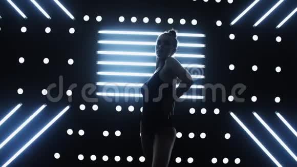 一个穿着内衣的漂亮而豪华的女人在聚光灯的背景下在黑暗的工作室里视频的预览图
