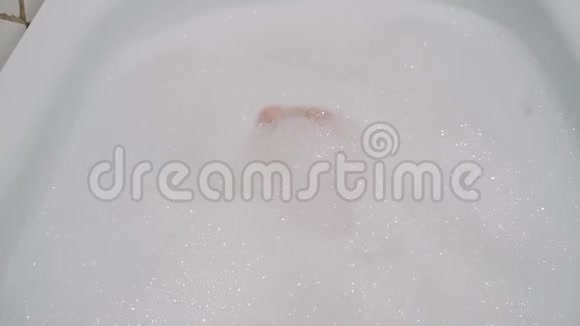 女孩在泡沫浴中用手指在脚上玩耍视频的预览图
