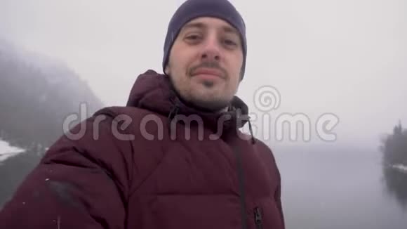 冬天人们在阿布哈兹的里萨湖上自拍并展示拇指视频的预览图