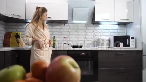 那个女孩在家在厨房里喝水微笑4K慢慢视频的预览图