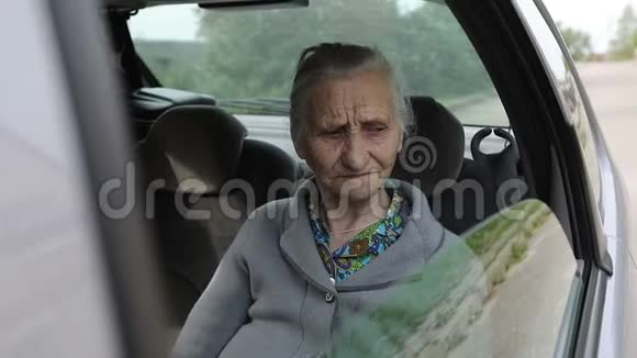 张开着的车窗上有着深深皱纹的老妇人的肖像视频的预览图