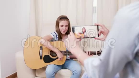妈妈拍了一段她小女儿用吉他演奏的视频视频的预览图