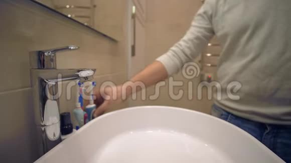 晨间常规男性手把牙膏放在牙刷上刷牙洗手池上视频的预览图