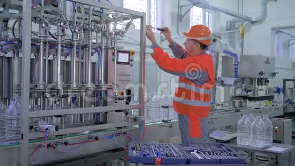 专业技术人员男头盔和工作服在皮带线附近使用专用工具进行翻新工厂设备视频的预览图