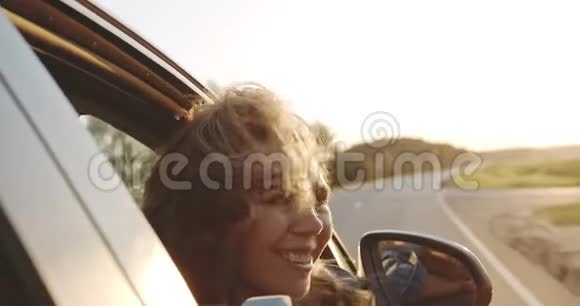 快乐的西班牙裔少女骑在敞篷车的后部举起手臂在空中视频的预览图