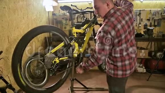 一名自行车技师在自行车修理店的长凳上修理一个山地自行车轮自行车修理视频的预览图