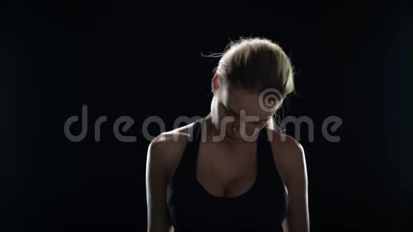 运动女性在黑色背景下为颈部做热身运动视频的预览图