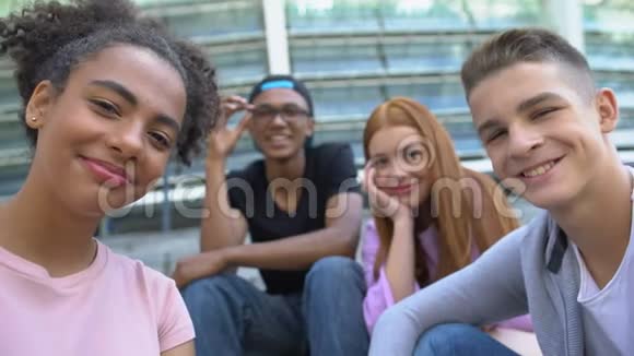 快乐的多民族青少年朋友在镜头前微笑休闲在一起视频的预览图