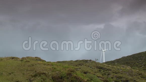 一个风车在雨云下的山脊上视频的预览图