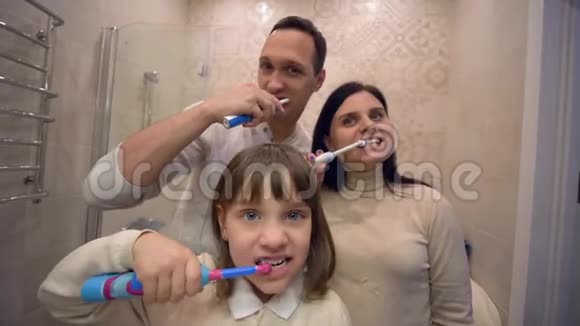 晨练健康的小女孩带着牙刷在镜子前刷牙视频的预览图