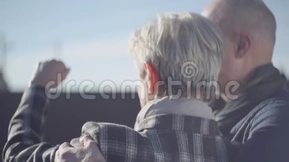 一位白发苍苍的女人的背影一位秃头男人的背影站在外面双手合拢一张来自烈阳的脸视频的预览图